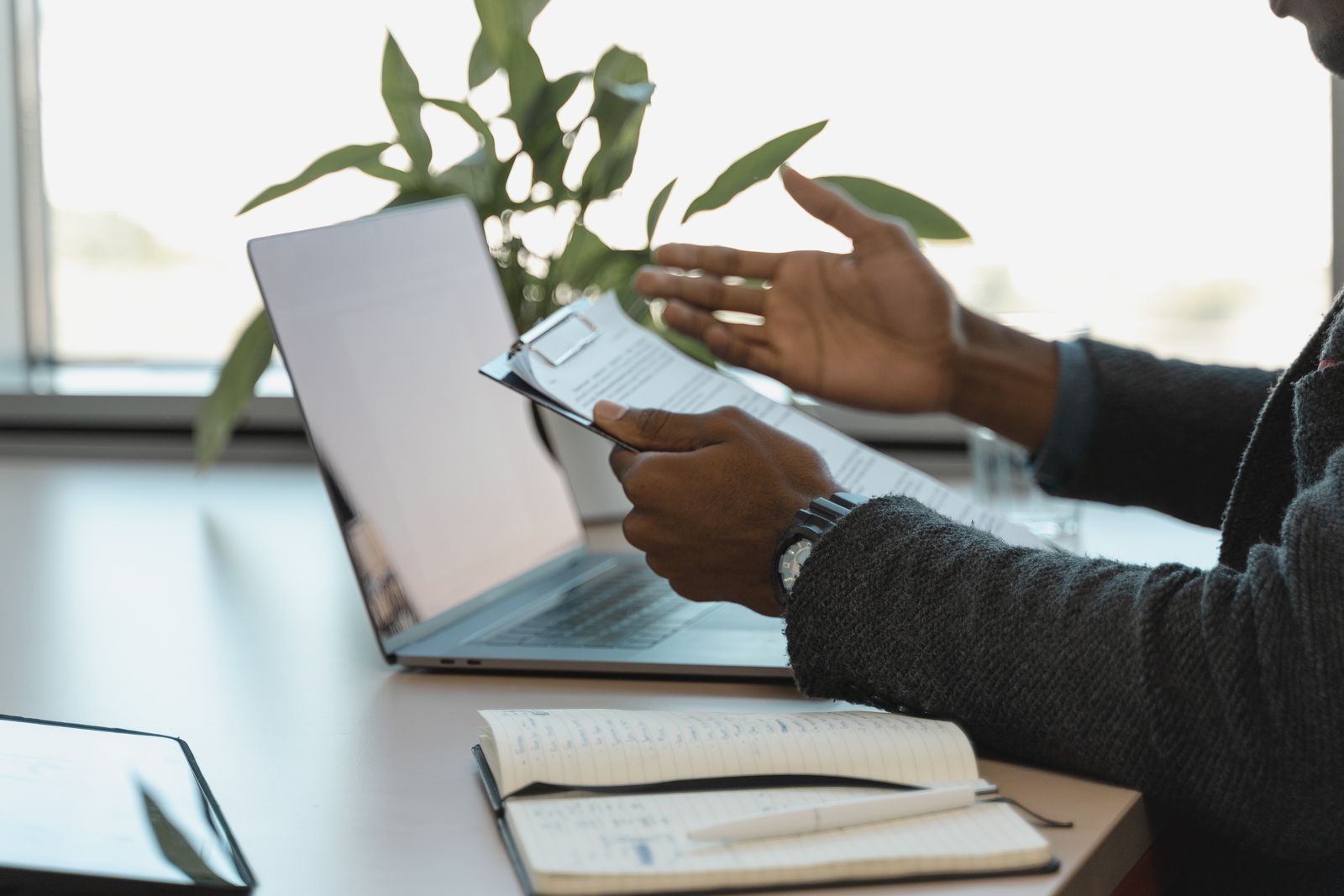 A business consultation with documents, notes and a laptop